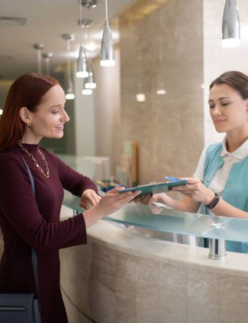 Dental team member helping patient with paperwork