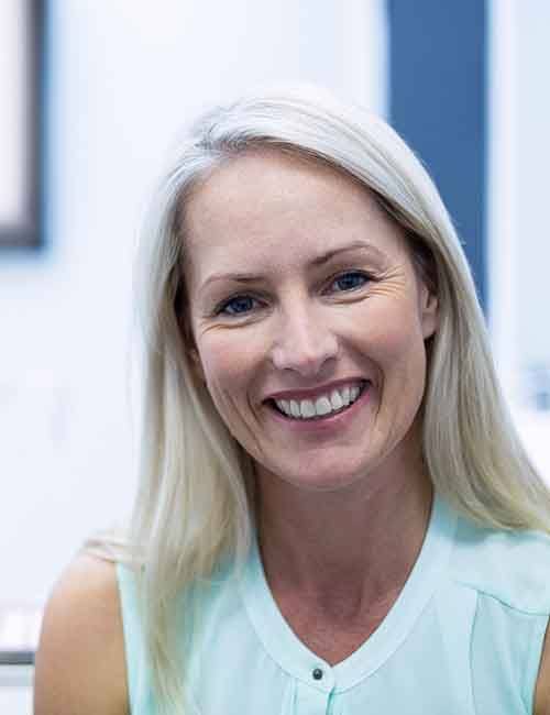 Smiling woman in dentist’s exam room