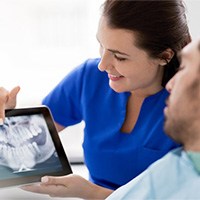 a dentist showing a patient an X-ray of their teeth