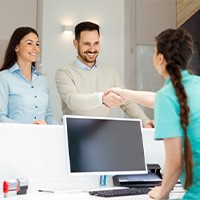 a couple speaking with a front desk team member