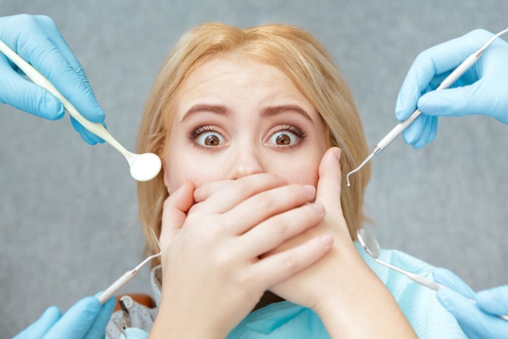 A woman covering her mouth at the dentist’s office